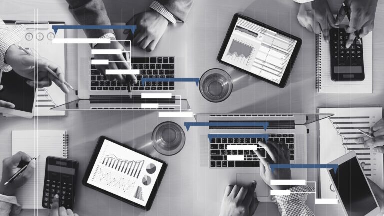 Robot hand holding a blank card in front of a Christmas tree, in soft natural light.