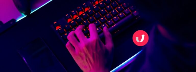 Hands typing on a laptop with neon purple and blue lighting, symbolising AI and multilingual digital communication.