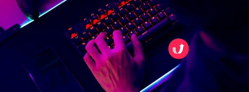 Hands typing on a laptop with neon purple and blue lighting, symbolising AI and multilingual digital communication.